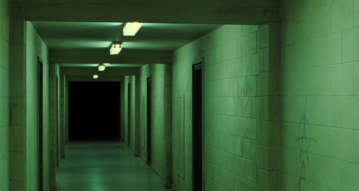 A green-tinted hallway with an extremely shadowy end.