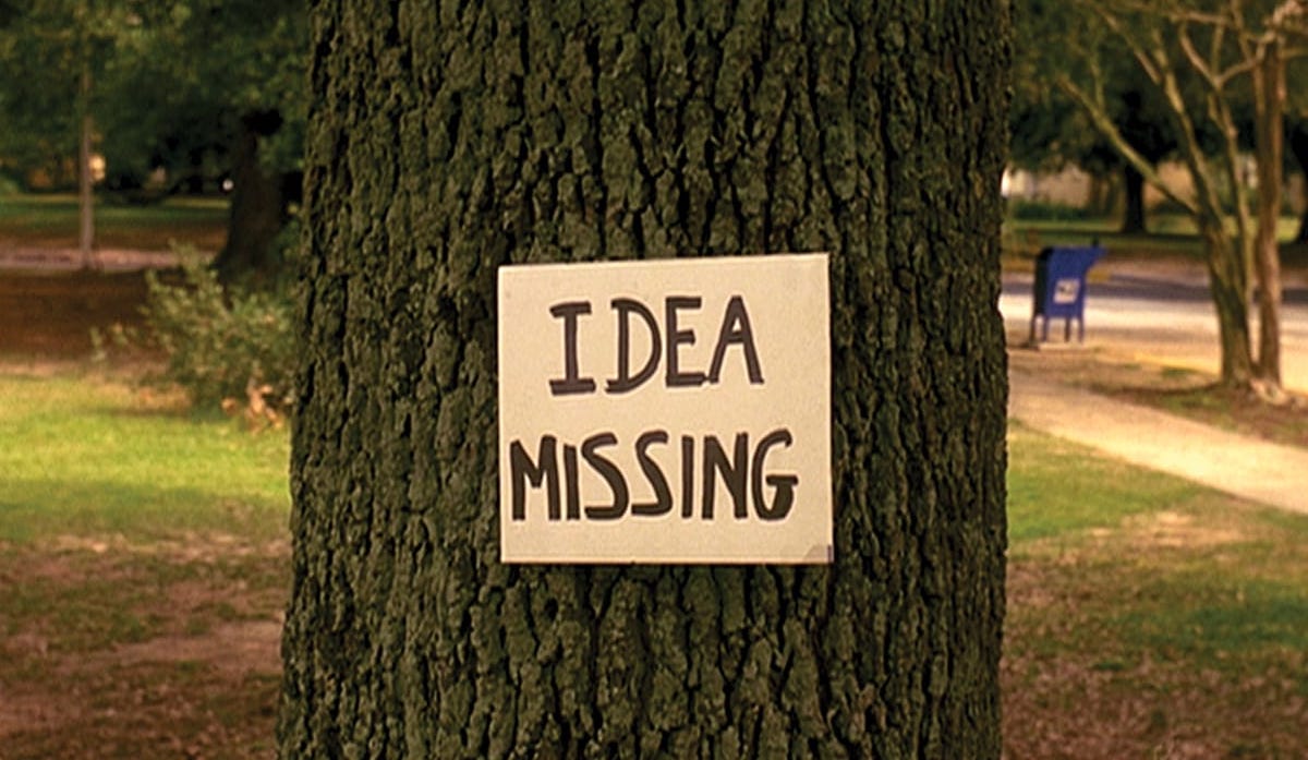 A placard reading "Idea Missing," pinned to a tree.