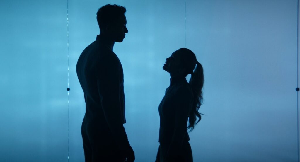 Two Starfleet Academy cadets stand silhouetted against a blue background. The one on the left, male, is well over a foot taller than the one on the right, female.