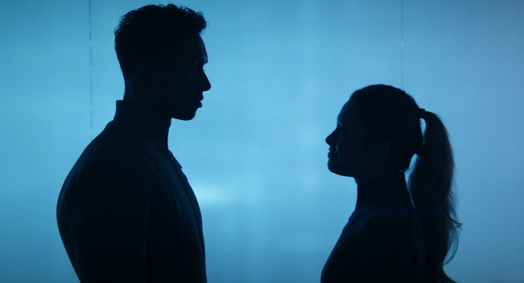 The same two Starfleet Academy cadets as in the prior image stand silhouetted against a blue background; the one on the right has grown 10-12 inches and is now nearly at eye level with the one on the right.