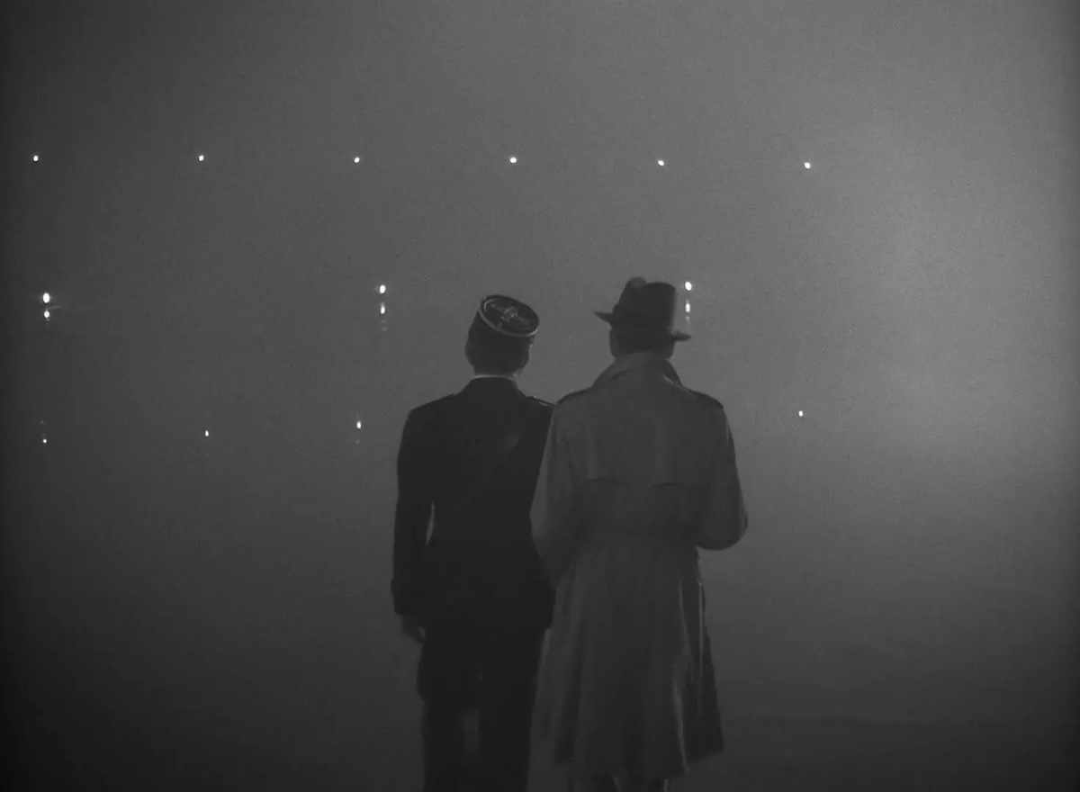 Two men walk away from camera into a foggy nothingness. The black and white still is from the final shot of the 1942 film Casablanca.